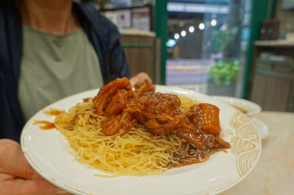 出典私ミシェリー@HKGlossy.comによる撮影. 麥奀雲吞麵世家の特效牛筋撈麺を私ミシェリーが持っているところ